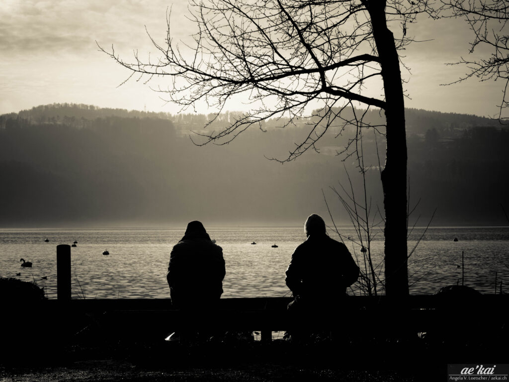Two people together but alone at Greifensee, Switzerland