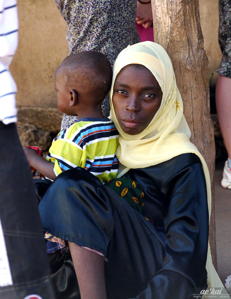 A woman with a yellow head scarf and a kid in Zanzibar