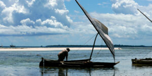 Fisher man with a traditional boat called a dhow in Zanzibar