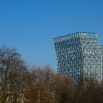 Dancing Towers (Tanzenden Türme) in Hamburg with trees in the foreground and against blue sky