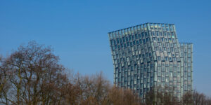 Dancing Towers (Tanzenden Türme) in Hamburg with trees in the foreground and against blue sky