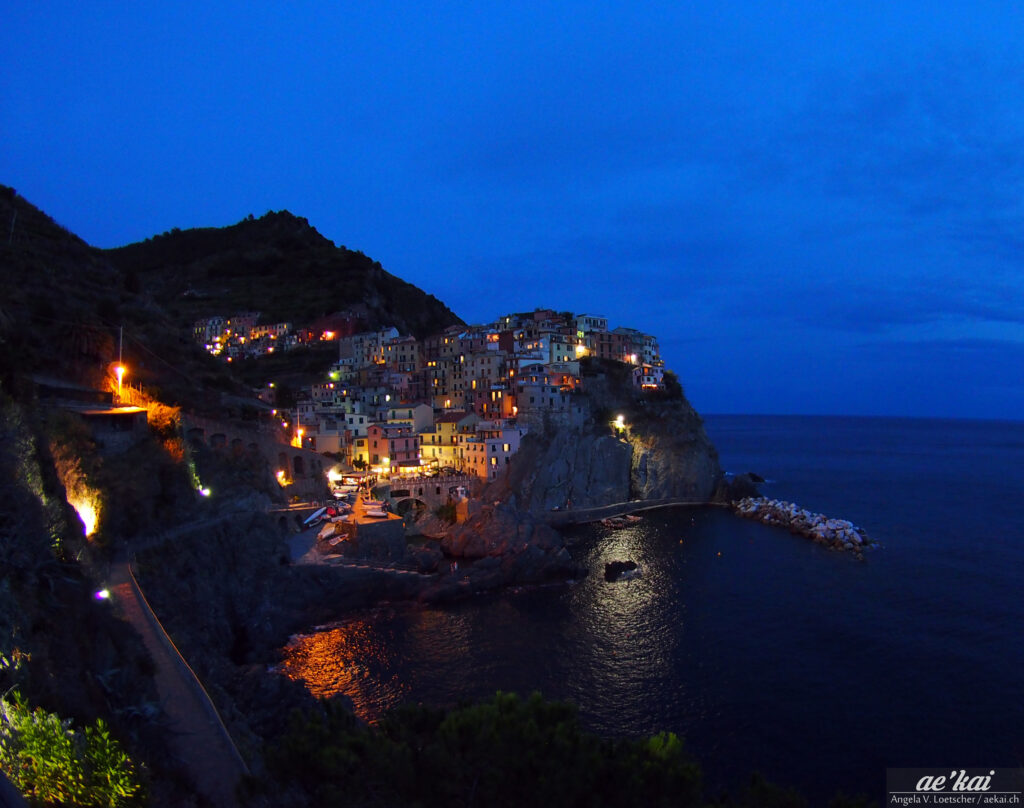 Manarola by night, blue hour and painted houses; Cinque Terre