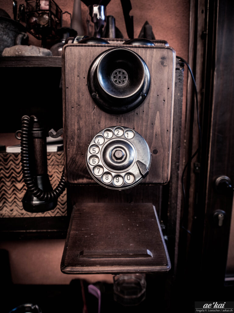 Old wooden phone with dialling disc in brown hues
