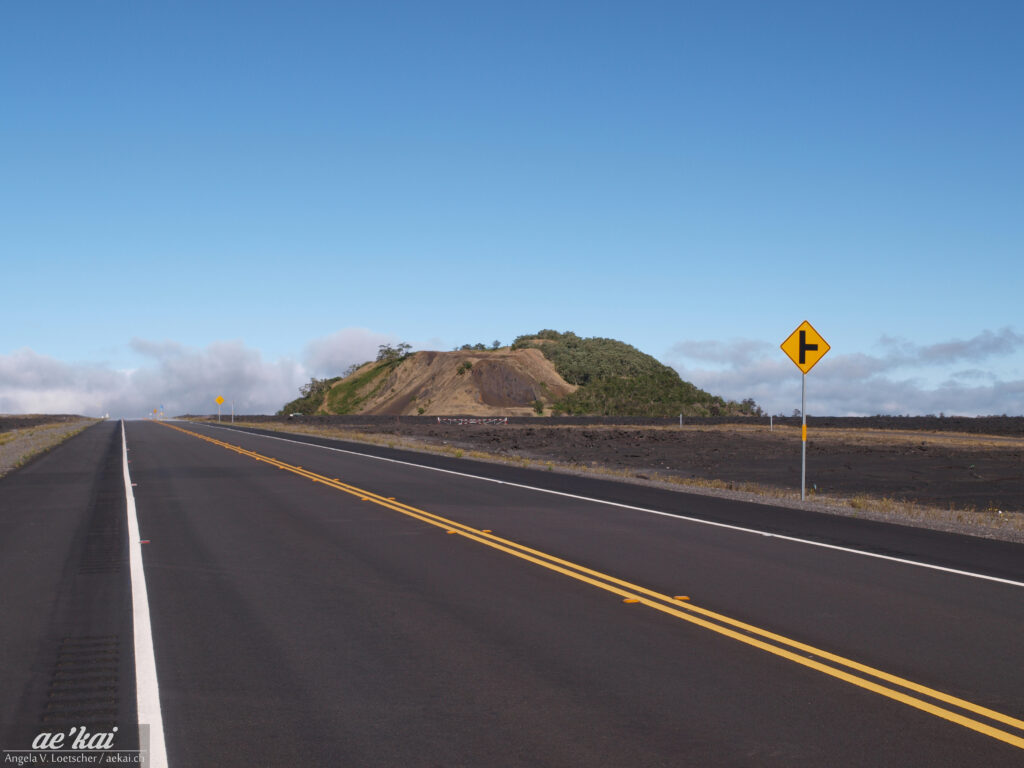 Saddle Road with crater on Big Island, Hawaii against blue sky