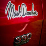 Car Detail with "Mark Donohue" logo and the number 390 on side of a door at a Swiss US Car Show.